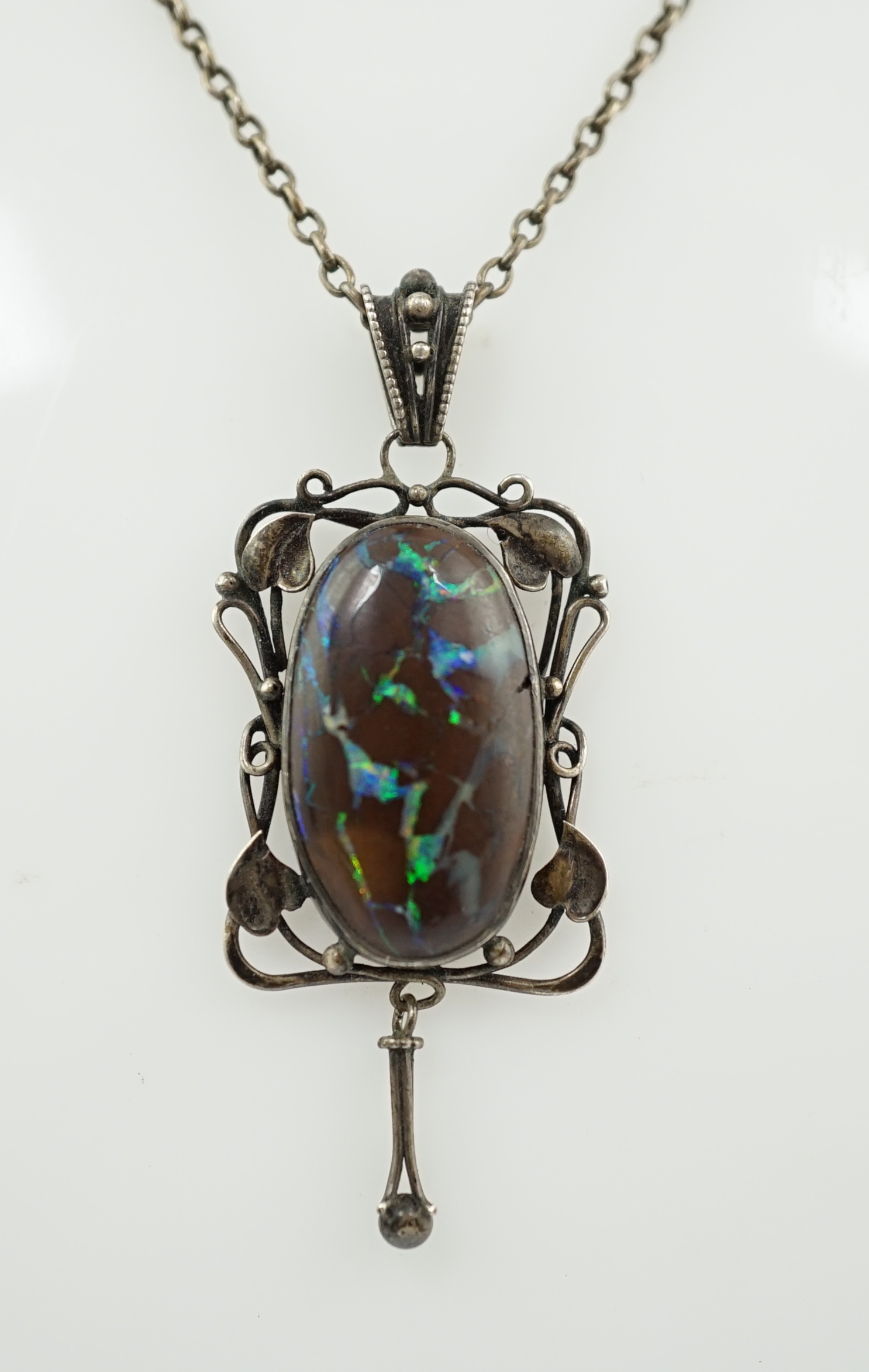 An Art Nouveau silver and oval black opal set drop pendant necklace